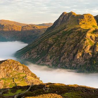 morning light shining on lake district mountains with cloud inversion